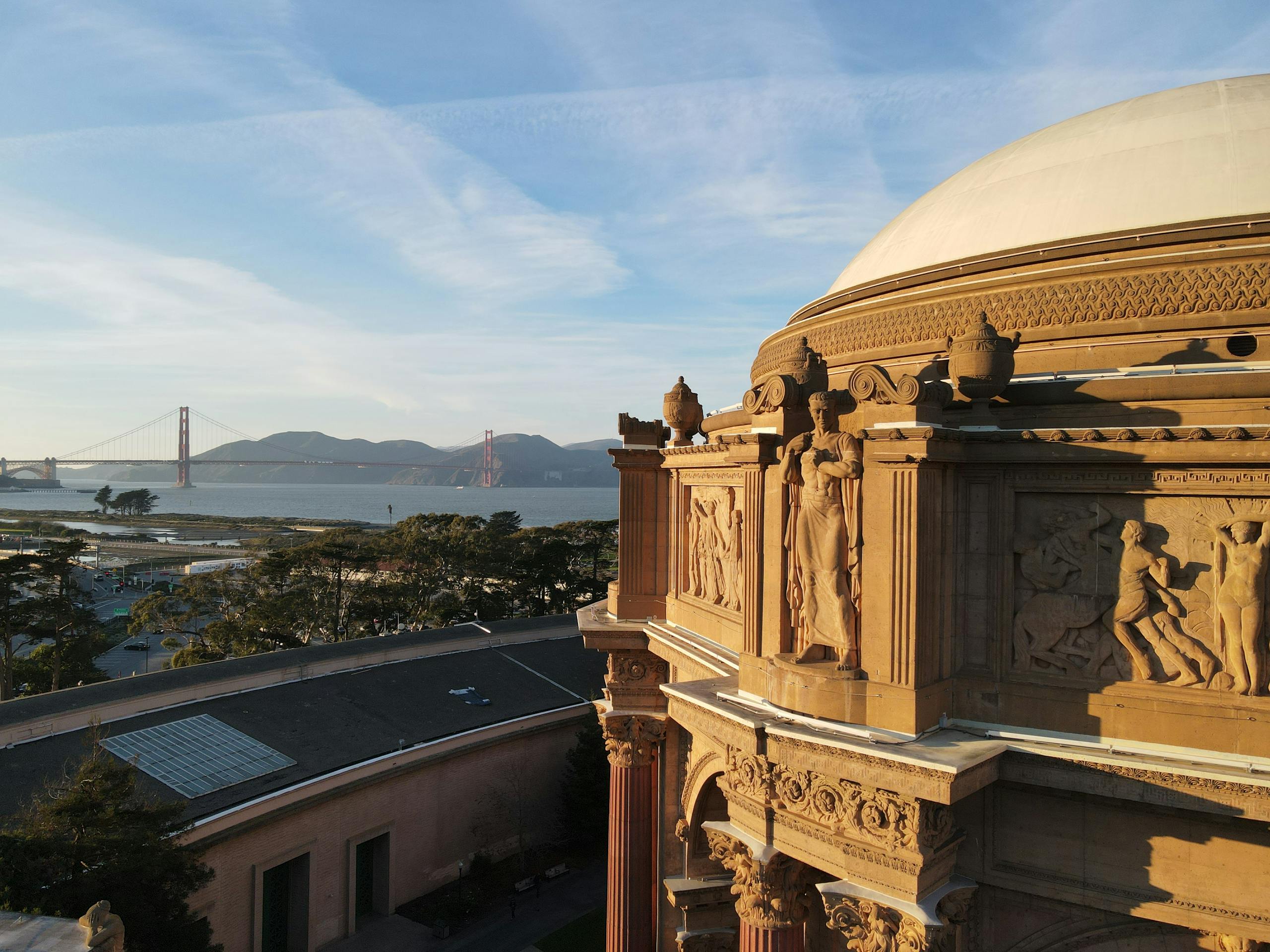 Scenic view of Palace of Fine Arts dome with Golden Gate Bridge in the background in San Francisco.