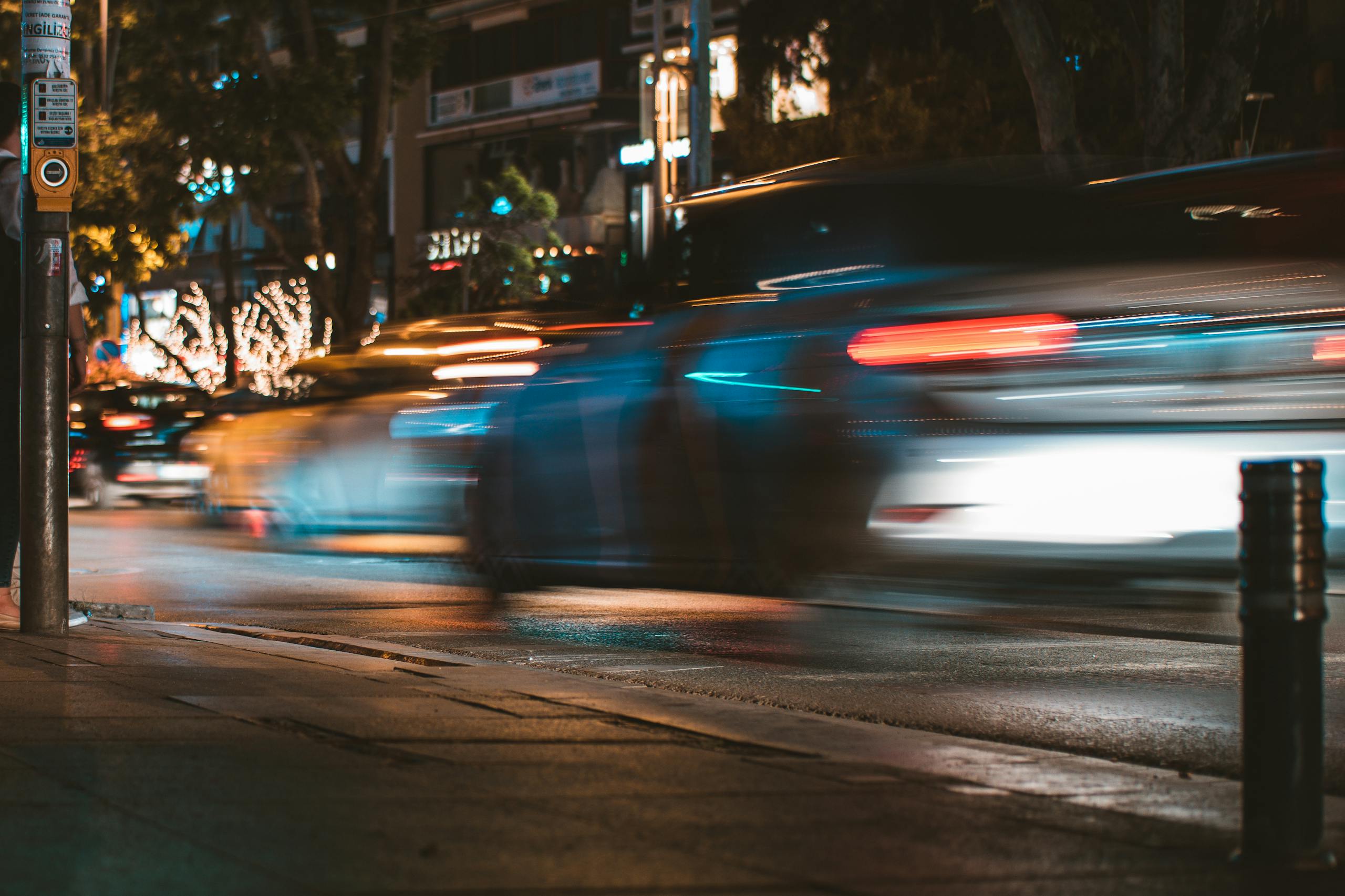 Long exposure capture of urban traffic showcasing light streaks and busy city life at night.